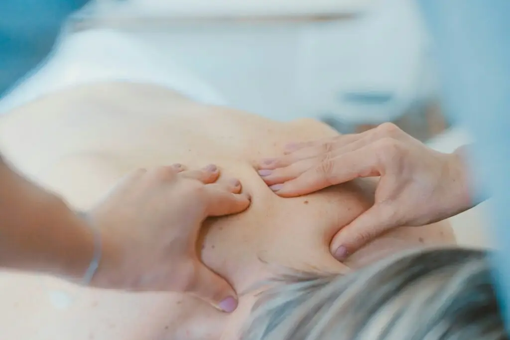 A professional massage therapist performing a deep tissue massage on a client's back to relieve muscle tension and improve circulation.